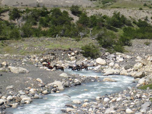 Horses cross a river Torres del Paine
